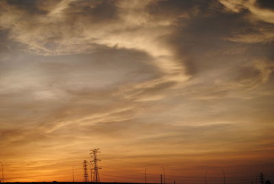Silhouette of electric pylon against sky