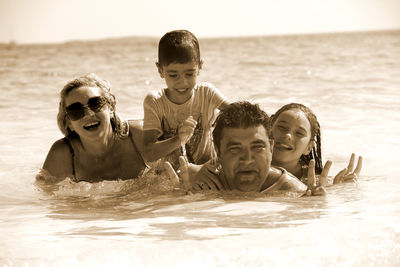 Portrait of happy family enjoying in sea on sunny day