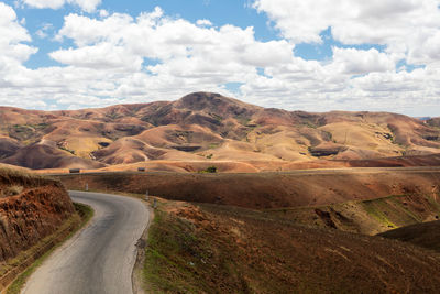 Road leading towards mountains against sky