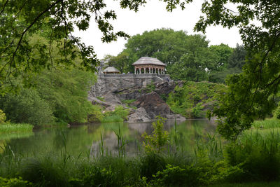 Gazebo on rock formation by lake in central park