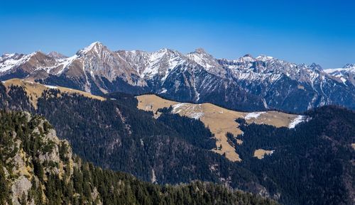 Scenic view of snowcapped mountains against clear blue sky