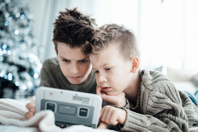 Portrait of boy holding camera at home