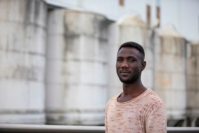 Portrait of young man standing against wall