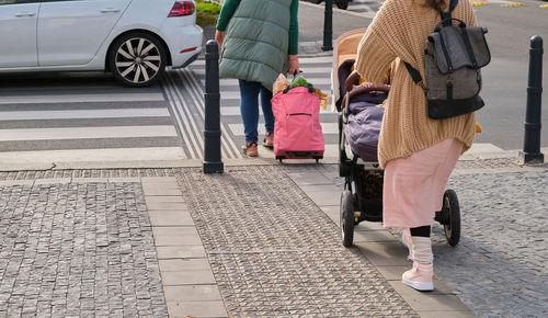 Low section of people walking on street