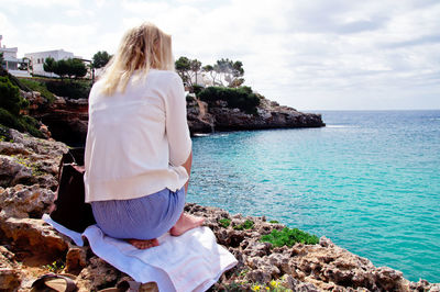 Rear view of woman looking at sea against sky