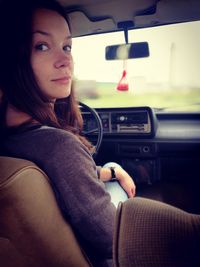 Young woman sitting in car