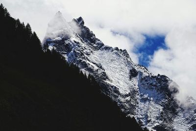 Low angle view of snowcapped mountain against sky