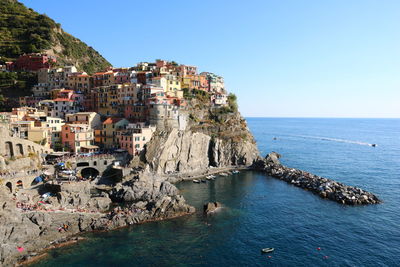 Scenic view of sea by buildings against clear sky