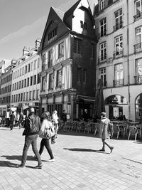 People walking on street against buildings in city