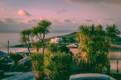 High angle view of townscape by sea against sky during sunrise