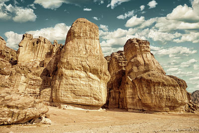 Rock formations against cloudy sky