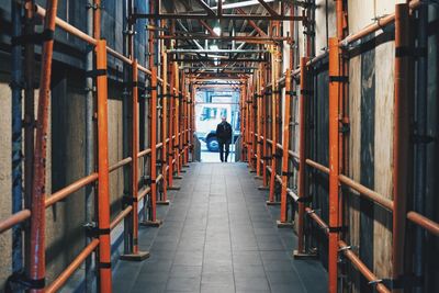 Rear view of man walking in corridor of building