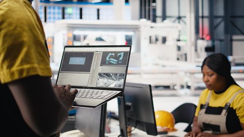Side view of young woman using laptop at office