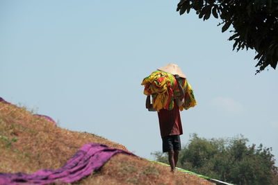 Rear view of woman walking against clear sky