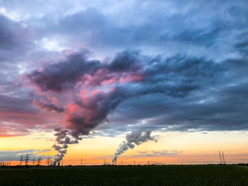 Scenic view of dramatic sky over land during sunset