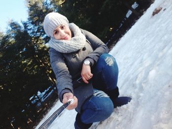 Full length portrait of smiling woman in snow