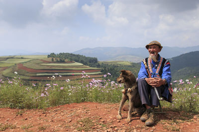 Full length of man standing on field against cloudy sky