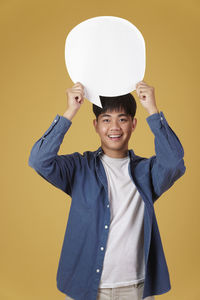 Portrait of a smiling boy against yellow background