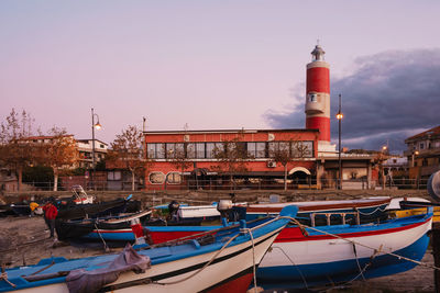 Boats moored in sea against buildings in city