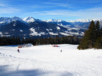 People skiing on snowcapped mountain against sky