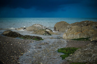 Rocks on beach against sky