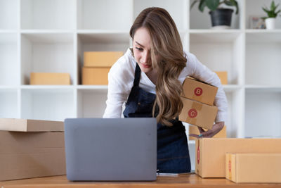 Young woman using laptop while sitting on table