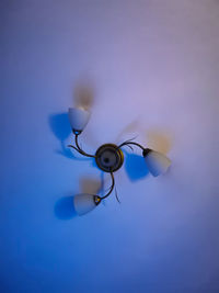 Low angle view of lamp against blue background