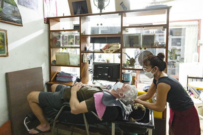 Senior man getting hair washed in hair salon