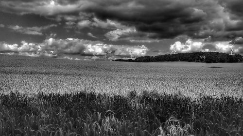 Scenic view of field against storm clouds