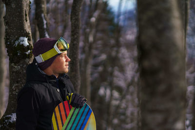 Man in warm clothing against trees