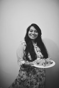Portrait of smiling young woman against white background