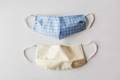 Homemade cloth face masks used during covid-19 on white backdrop.