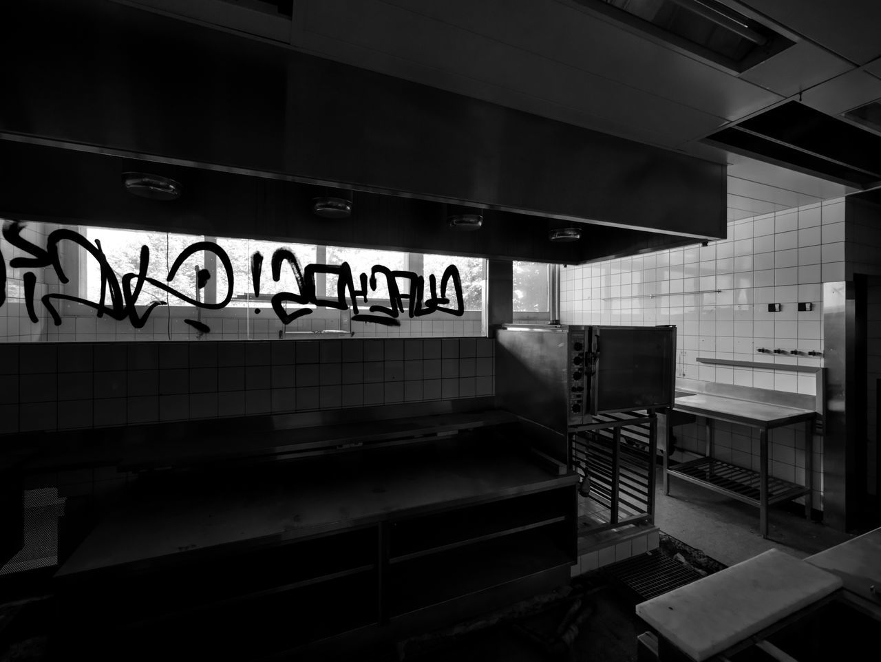 architecture, black, text, monochrome, indoors, black and white, communication, no people, sign, western script, built structure, monochrome photography, interior design, darkness, light, white, subway station, seat