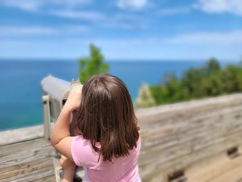Rear view of woman looking at sea against sky