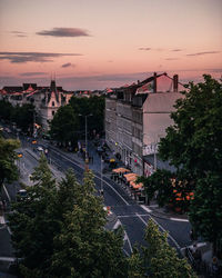 High angle view of street amidst buildings against sky during sunset