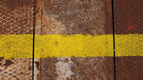 Single yellow line on rusty metal