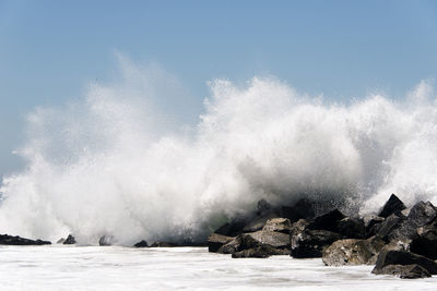 An extreme high wave crashing to rocks in the beach of venice, california in summertime
