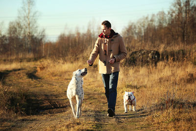 Man with dog standing on field