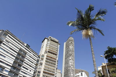 Low angle view of modern buildings against blue sky