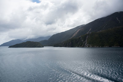 Scenic view of sea and mountains against sky