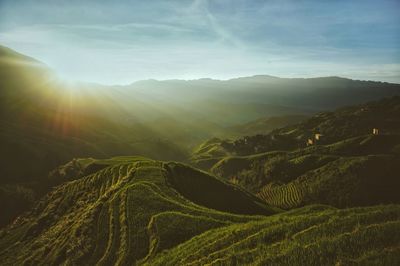 Scenic view of rice terraces against cloudy sky during sunrise