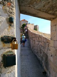 Rear view of man standing in front of built structure