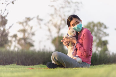 Woman holding dog on field