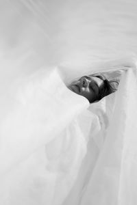 High angle view of woman face amidst fabric