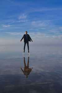 Man standing in sea against sky