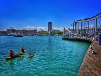 Boats in calm sea against clear sky