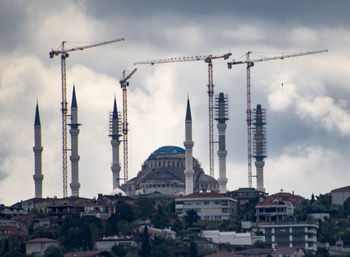 Buildings in city against cloudy sky