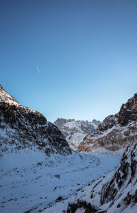 Scenic view of snowcapped mountains against clear blue sky