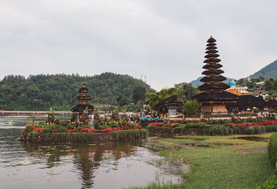 Traditional building against sky with lake in background