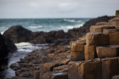 Stack of stones on beach against sky